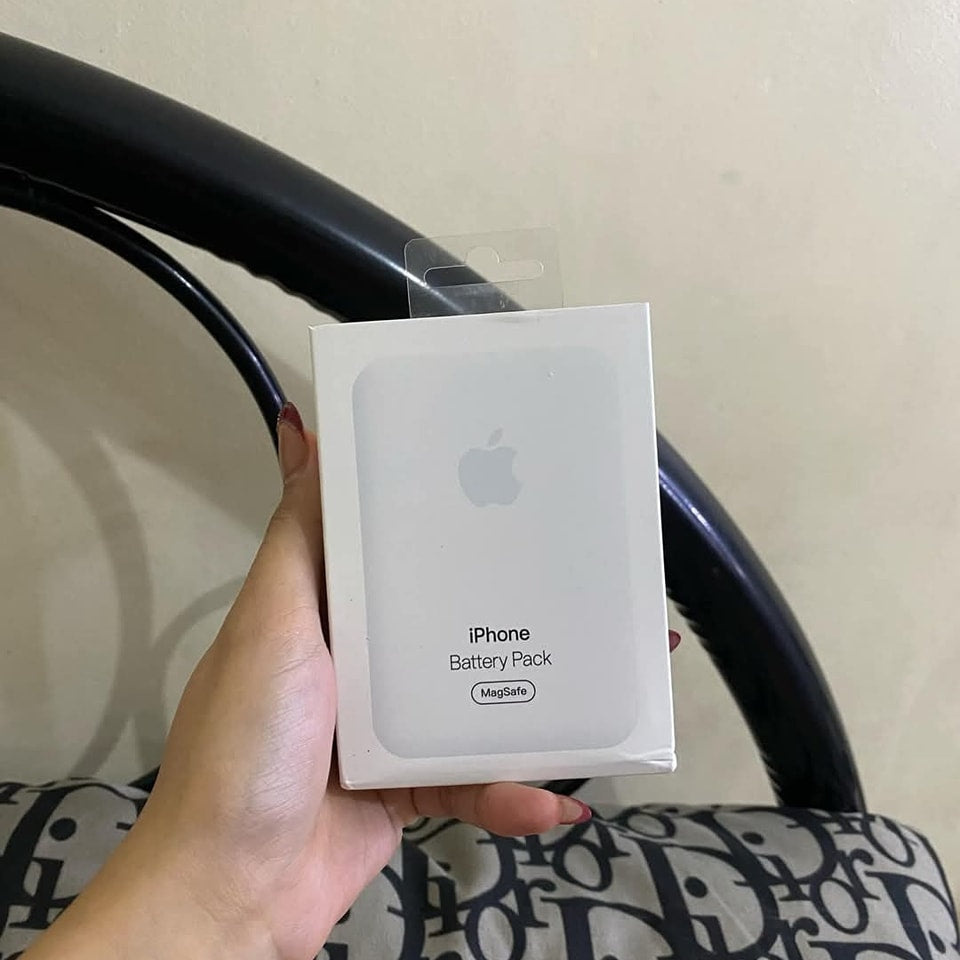 Hand holding an Apple iPhone Battery Pack box against a neutral background