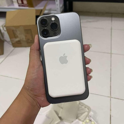 Hand holding a smartphone with a MagSafe case in an indoor setting